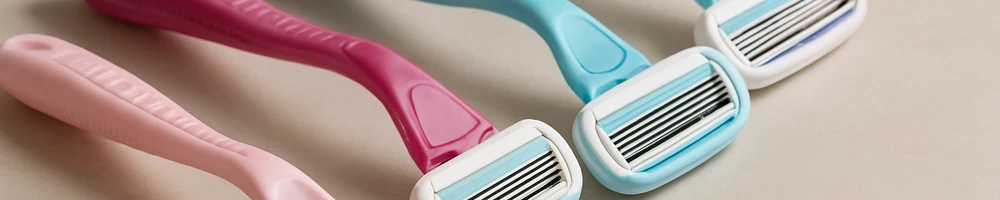 Maquinilla de afeitar para mujer sobre fondo neutro