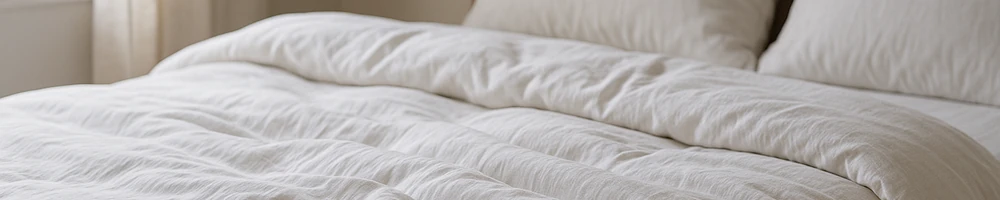 Nórdico blanco sobre cama, detalle del tejido y relleno